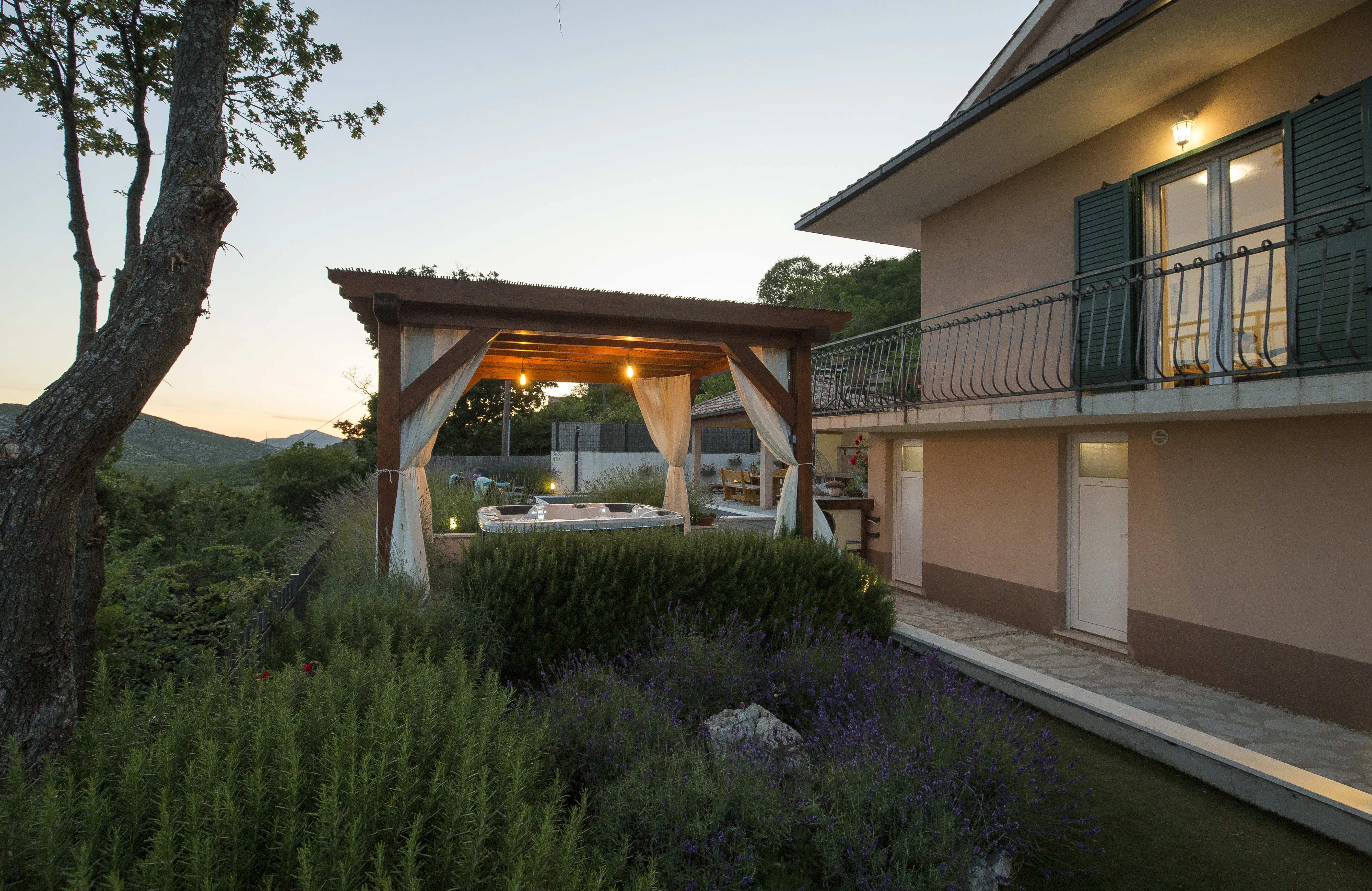 Villa exterior at dusk, lights on